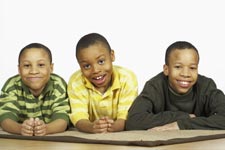 three African American boys. The two on the sides look more alike, but they are not twins