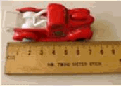 A picture of a toy truck measured against a meter stick. The back of the truck is placed at the left end of the meter stick. The front of the truck reaches to a measurement of 7.5 cm.
